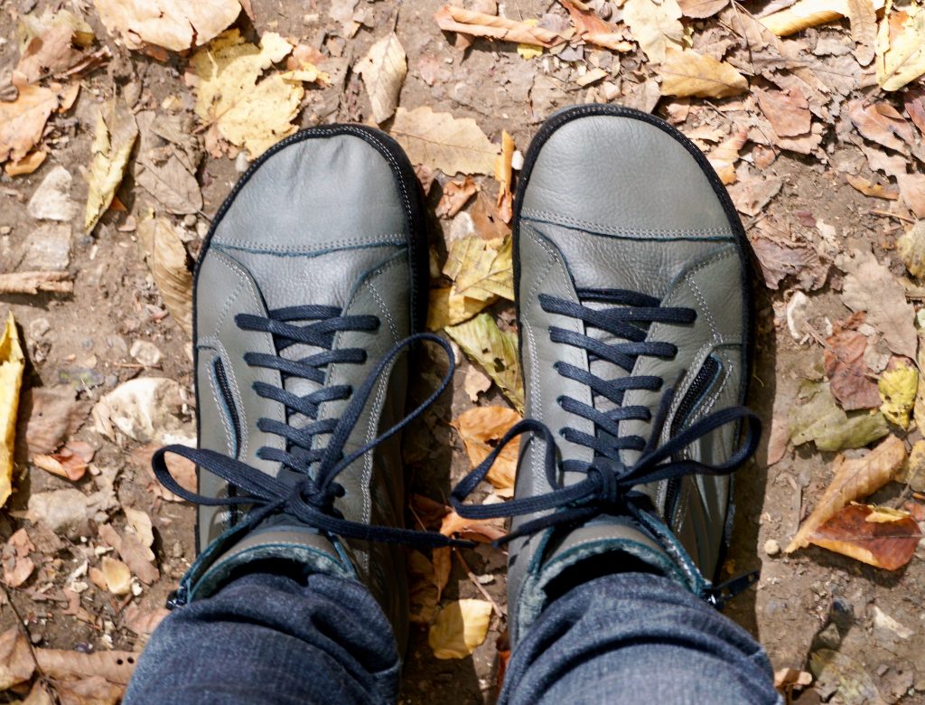 egy pár szürke Magical Alaskan X téli barefoot csizma felülnézetben az őszi avaron